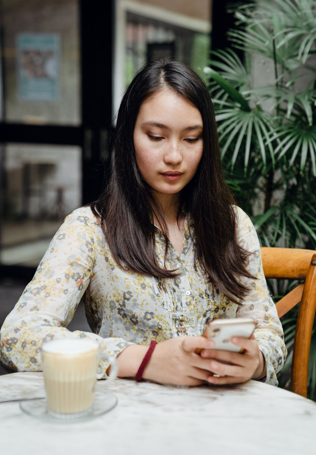 A café customer tipping from her phone at the table